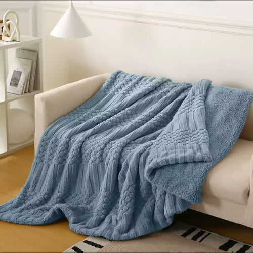 Chunky Knit Sherpa Throw Blanket — Blue draped over a cream sofa